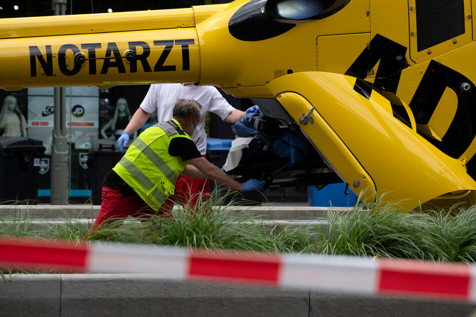 Mitarbeiter vom Rettungsdienst schieben eine Trage in einen Hubschrauber.