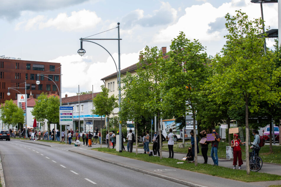 Protestierende stehen während einer Protestaktion nahe dem Polizeipräsidium, von dem aus eine Menschenkette zum Büro der Partei Bündnis 90 / Die Grünen führen soll.