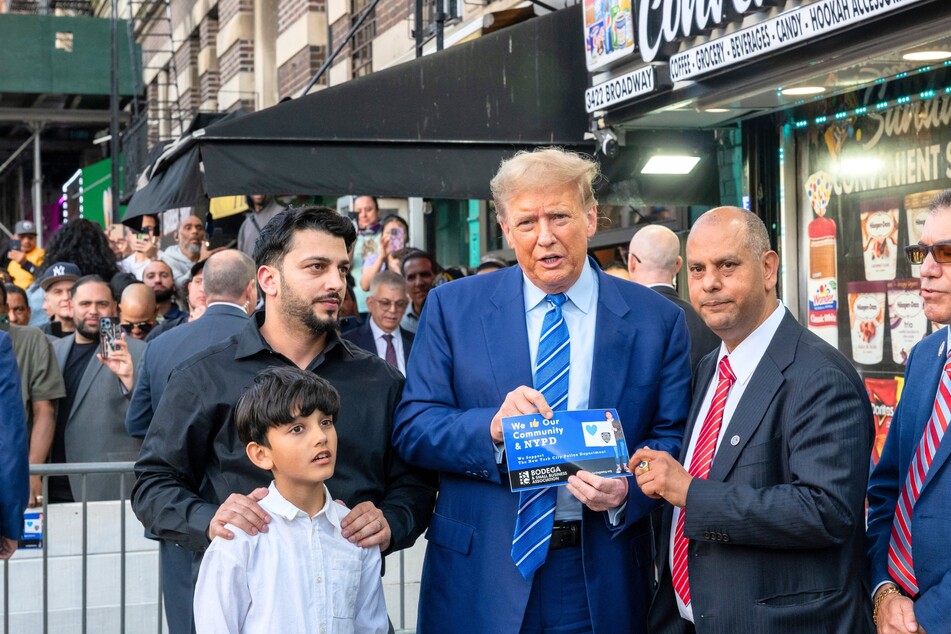 Former President Donald Trump (c.) standing with local politicians and bodega workers as he visits a convenience store in Upper Manhattan on April 16, 2024.