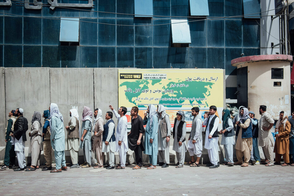 Afghan civilians line up outside a bank in the capital city of Kabul.