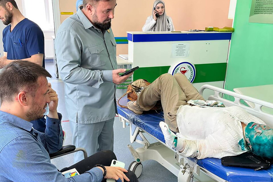 Human rights commissioner in the Chechen Republic Mansur Soltaev (c.) talks to journalist Yelena Milashina (r.) after she was attacked by unidentified men.