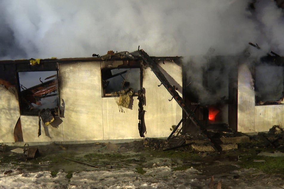 Von dem Gebäude blieb kaum etwas stehen. Ein Bagger reißt die Reste ab, um Glutnester sichtbar zu machen.