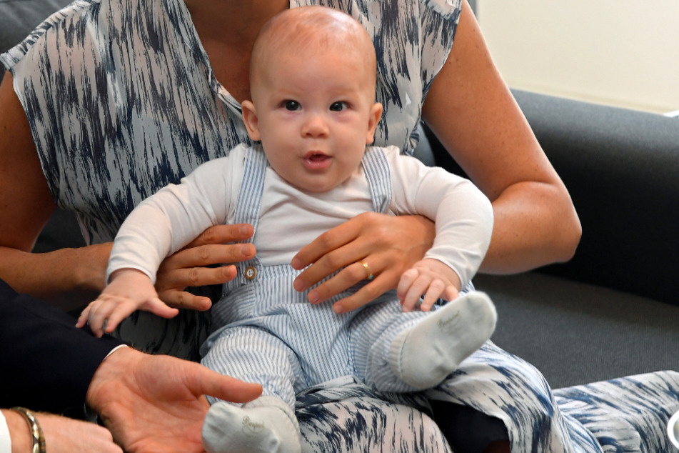 Südafrika, September 2019: Archie sitzt während eines Besuchs in Kapstadt auf dem Schoß seiner Mutter.