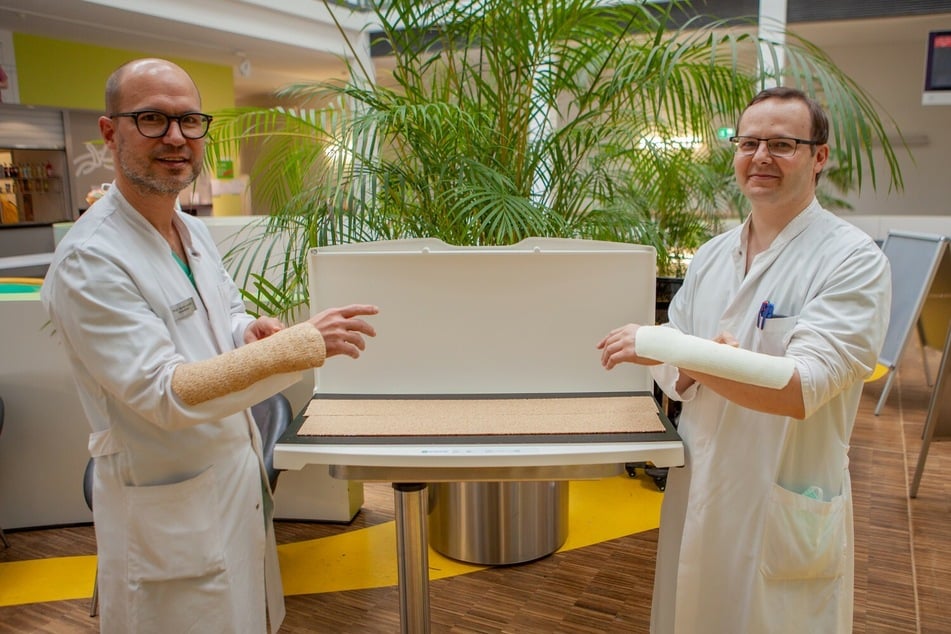 Prof. Martin Lacher (links), Direktor der Klinik und Poliklinik für Kinderchirurgie, mit einem Holzgips, Studienleiter Dr. Ilya Martynow mit einem herkömmlichen Plastikgips.