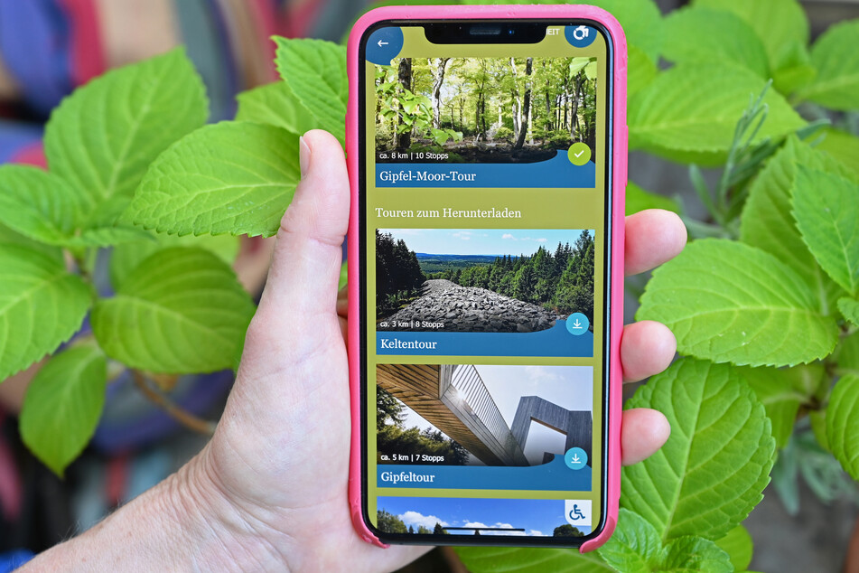 Eine Naturfreundin hält ein Smartphone mit der App des Nationalparks Hunsrück-Hochwald, die unter anderem digitale Touren durch das ausgedehnte Gebiet vorführt. Mit der App wollen Rheinland-Pfalz und Saarland das Gebiet bekannter machen und sein touristisches Potenzial besser erschließen.