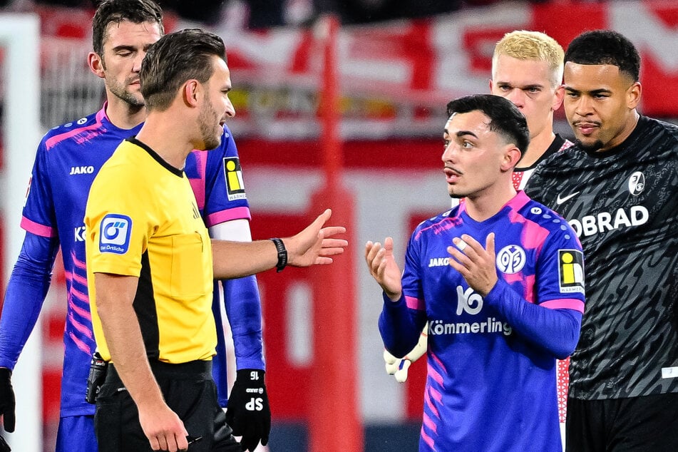 Schiedsrichter Benjamin Brand (2.v.l.) erklärt Paul Nebel (M.), warum er gerade den roten Karton gesehen hat. Gegen den SC Freiburg flog der Mainzer Dribbler in dieser Saison bereits zum zweiten Mal vom Platz.