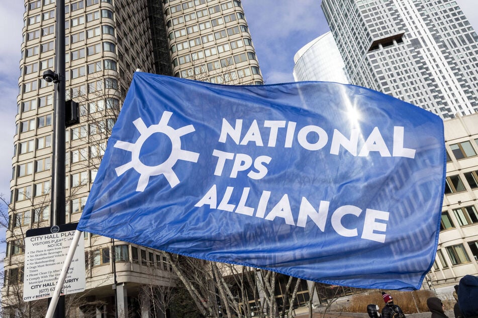 Immigrants' rights advocates wave a National TPS Alliance flag in Boston, Massachusetts.