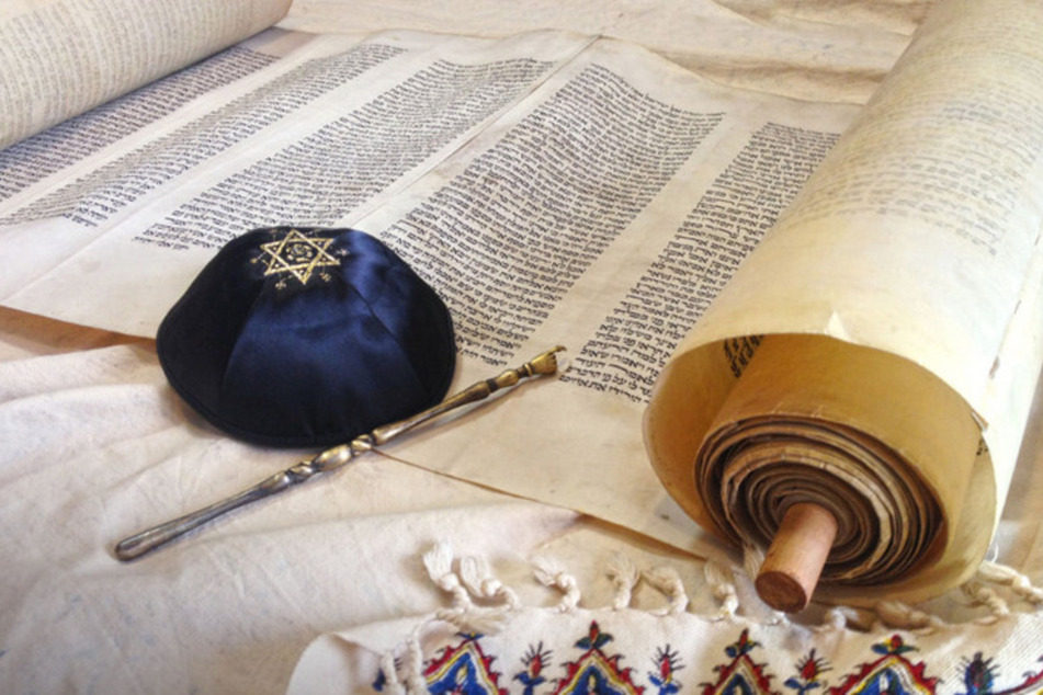 Symbole des Judentums: handgeschriebene Tora, reich verzierte Kippa und silberner Jad.