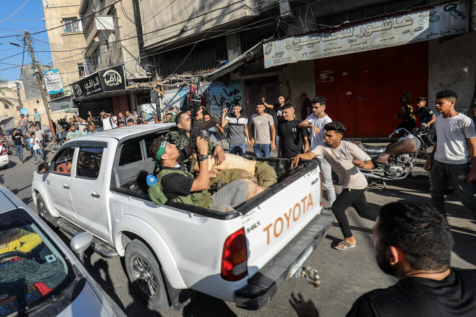 Militante Palästinenser in Khan Yunis umringen einen Lastwagen, der angeblich einen gefangenen Israeli transportiert.