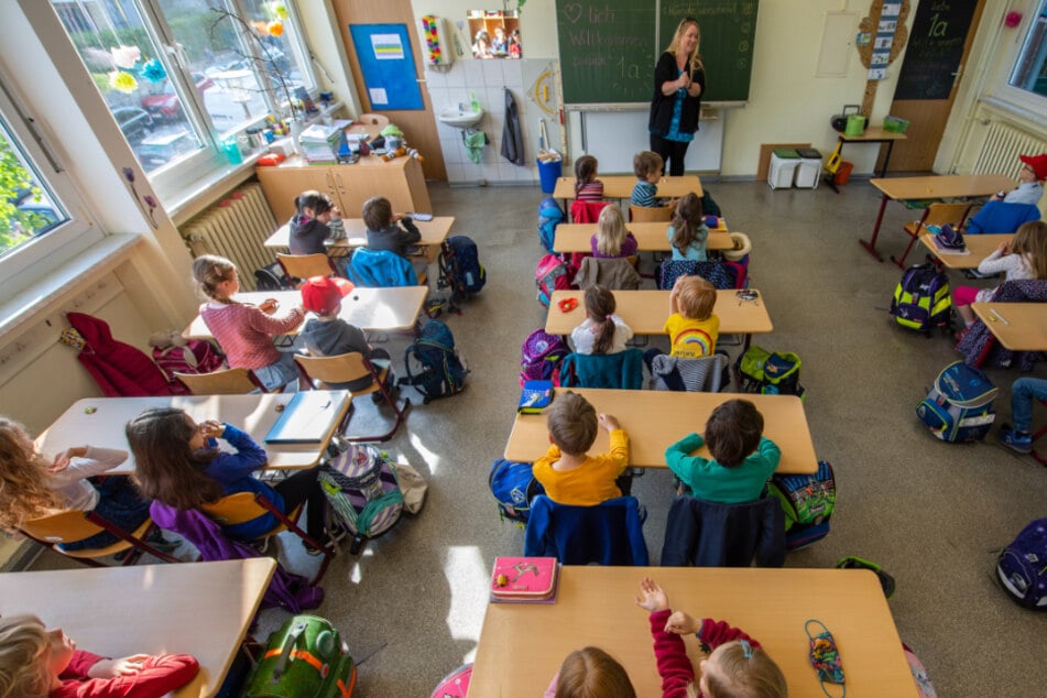 Schüler einer Grundschulklasse sitzen auf ihren Plätzen.