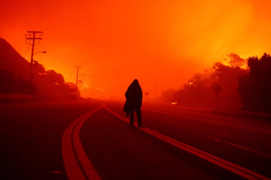 Eine Person geht die Malibu Canyon Road entlang, während sich das "Franklin Fire" nähert.