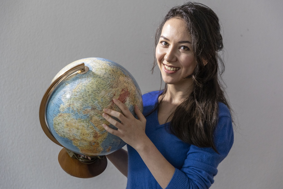 Kristina (26) zeigt auf dem Globus, wo ihre Heimat liegt.