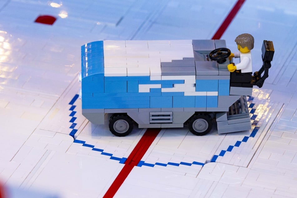 Die Eisbearbeitungsmaschine fährt über das Eis aus Klemmbausteinen.