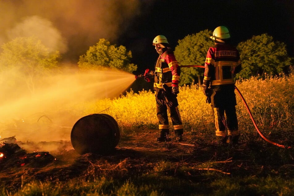 Damit die Flammen nicht auf die angrenzenden Wiesen überspringen, müssen die Einsatzkräfte die Ränder des Brandes gründlich ablöschen.