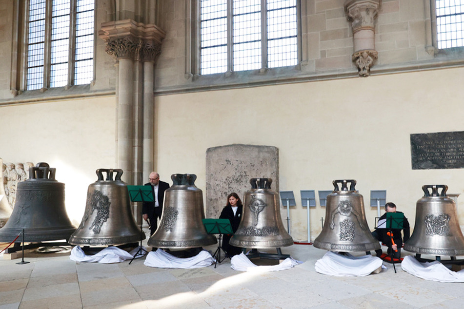 Musiker schlagen im Dom die fünf neu gegossenen Glocken für das Magdeburger Domgeläut während eines Festgottesdienstes.
