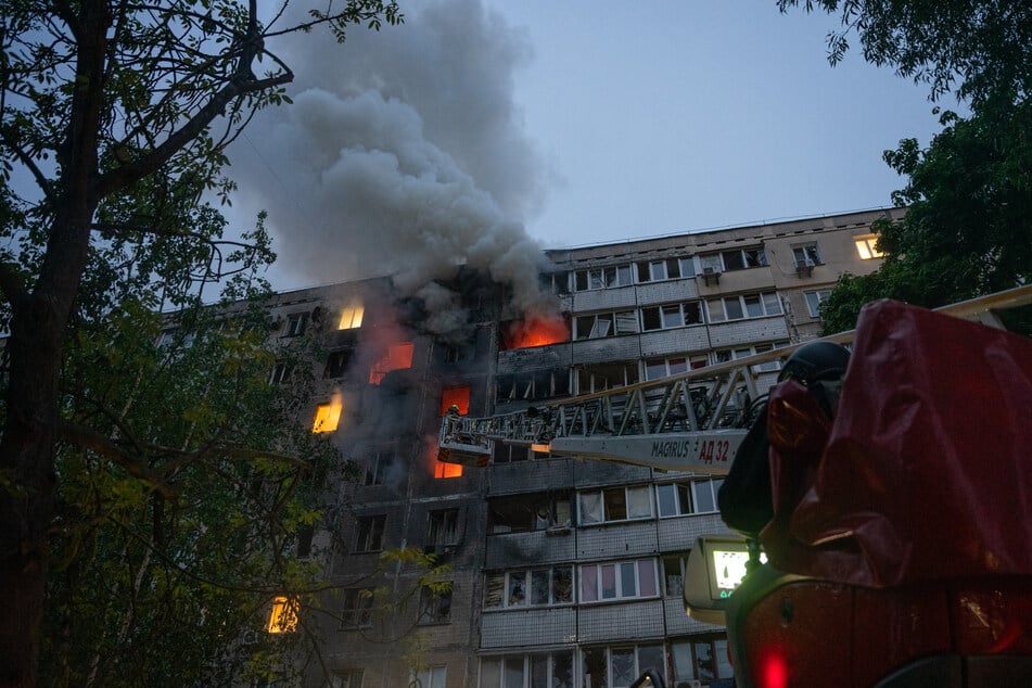 This handout photograph taken and released by the State Emergency Service of Ukraine shows rescuers putting out a fire in a residential building following a Russian drone attack, in Kyiv, on Wednesday, amid the Russian invasion of Ukraine.