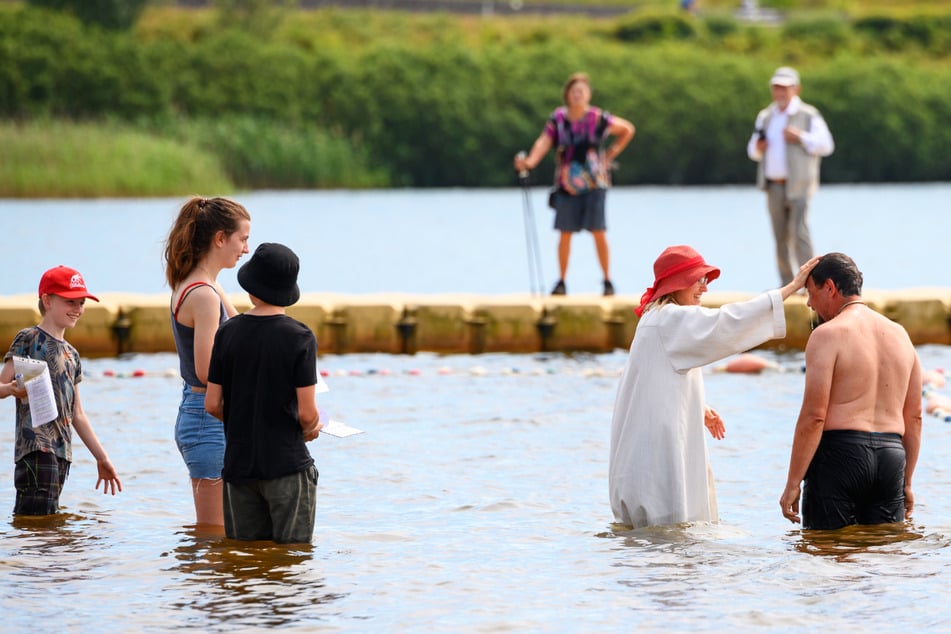 In Norderstedt wurden am Sonntag 57 Menschen im Alter von drei Monaten bis 57 Jahren im Stadtparksee getauft. Rund 500 Gäste waren mit von der Partie.