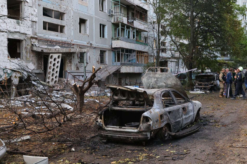 Verbrannte Autos und beschädigte Wohngebäude sind nach einem russischen Angriff in Saporischschja zu sehen.