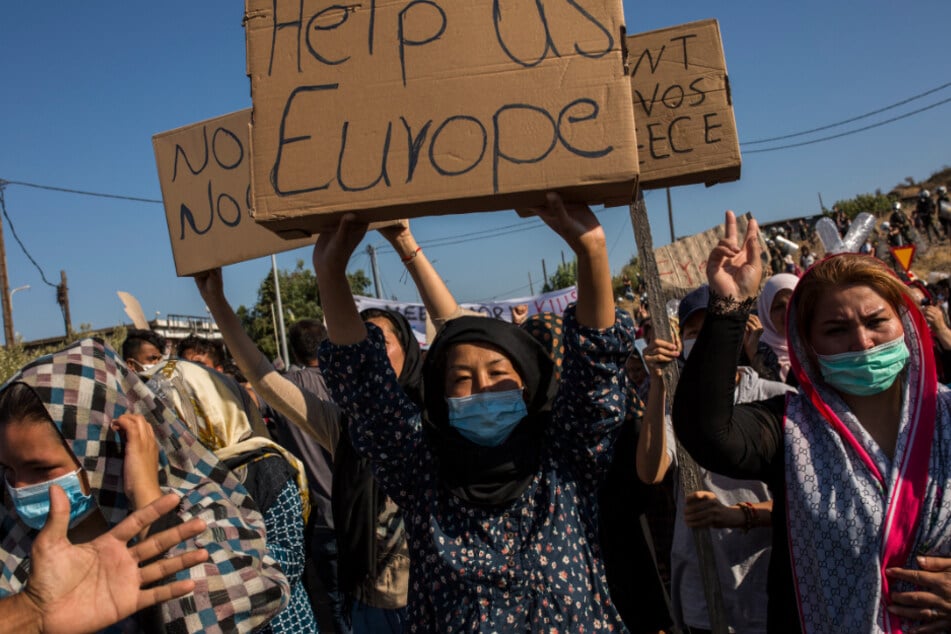 Eine Frau hält einen Karton mit der Aufschrift "Hilf uns Europa" während eines Protestes nach den Nachrichten über die Schaffung eines neuen provisorischen Flüchtlingslagers auf der Insel Lesbos hoch.