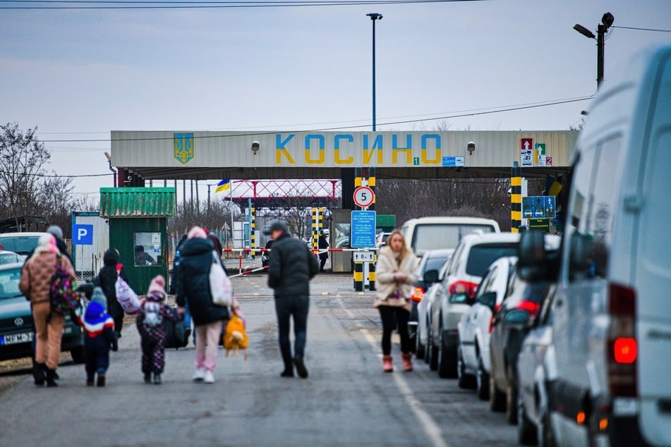 Fahrzeuge stehen am ukrainisch-ungarischen Grenzübergang Kosson.