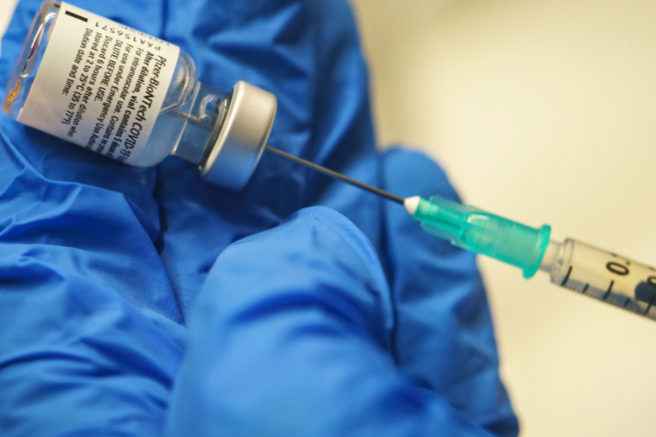 Ein Arzt bereitet im hessischen Impfzentrum im Kongresszentrum Darmstadtium eine Dosis mit dem Impfstoff von Biontech-Pfizer für eine Impfung vor.