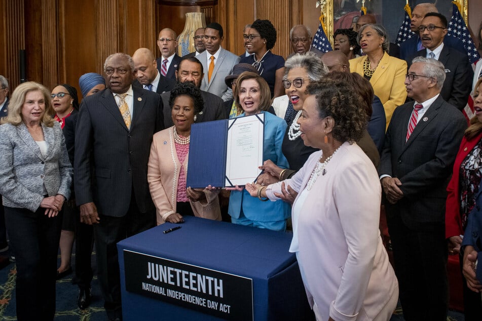 Speaker of the House Nancy Pelosi (c.) was joined by members of the Congressional Black Caucus as she held up the bill for the Juneteenth National Independence Day Act at the US Capitol on Thursday.