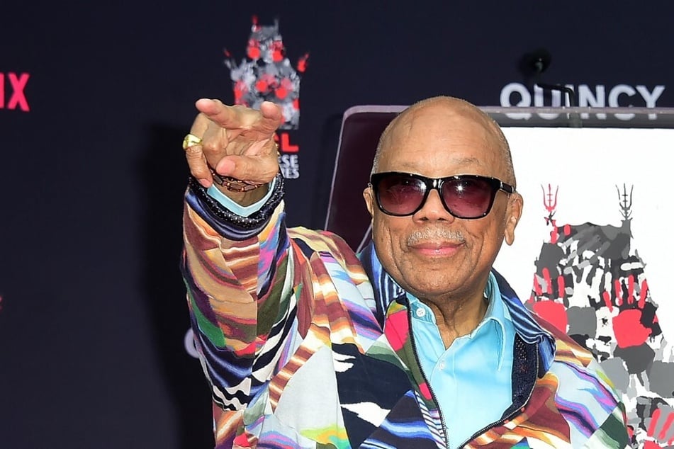 Composer and producer Quincy Jones points to his fans during his Hand and Footprints ceremony at the TCL Chinese Theater in Hollywood, California, on November 27, 2018.