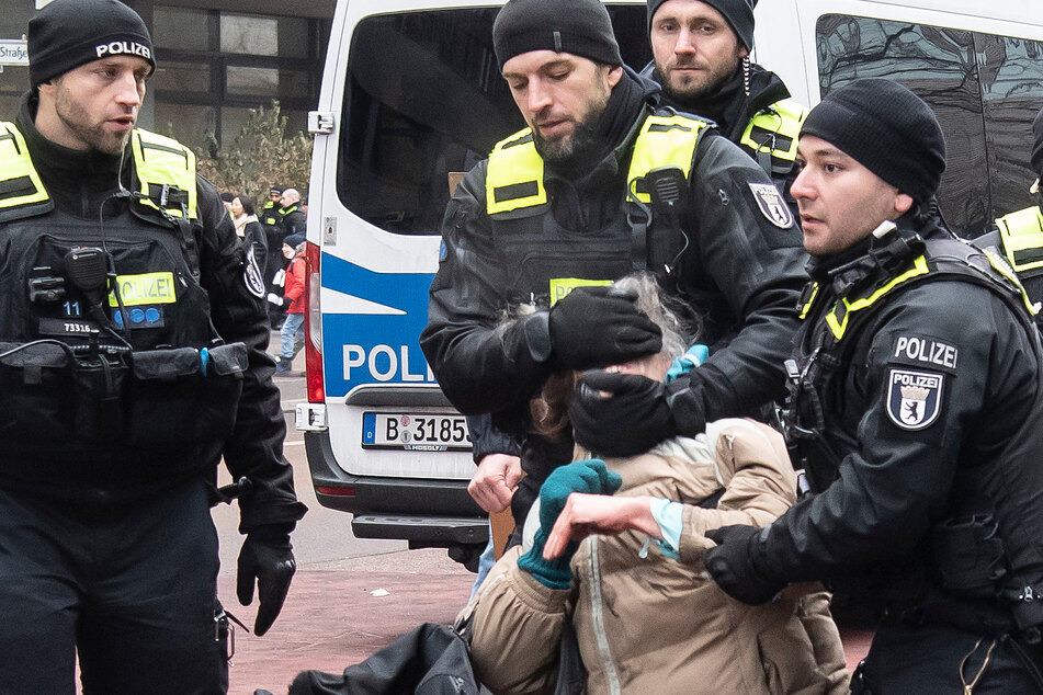 Die Berliner Polizei führt eine Klimaschutz-Aktivistin der Letzten Generation ab, die zuvor an einer Straßenblockade am Potsdamer Platz beteiligt war.
