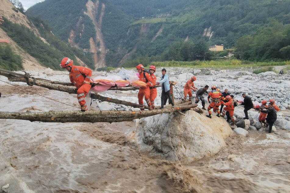 Rettungskräfte bringen Überlebende in die Stadt Moxi im Kreis Luding.