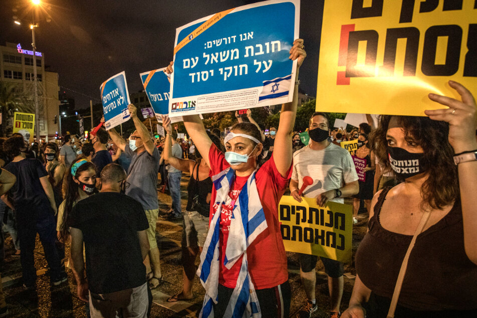Tel Aviv: Demonstranten halten Plakate während einer regierungskritischen Demonstration hoch.