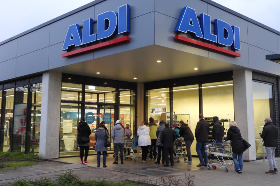 Kunden stehen vor der noch geschlossenen Aldi-Filiale.