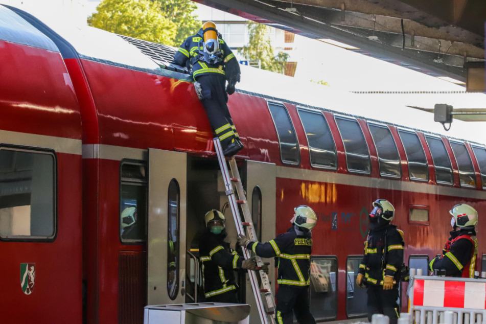 Feuerwehrleute untersuchen einen Zug im Hauptbahnhof.