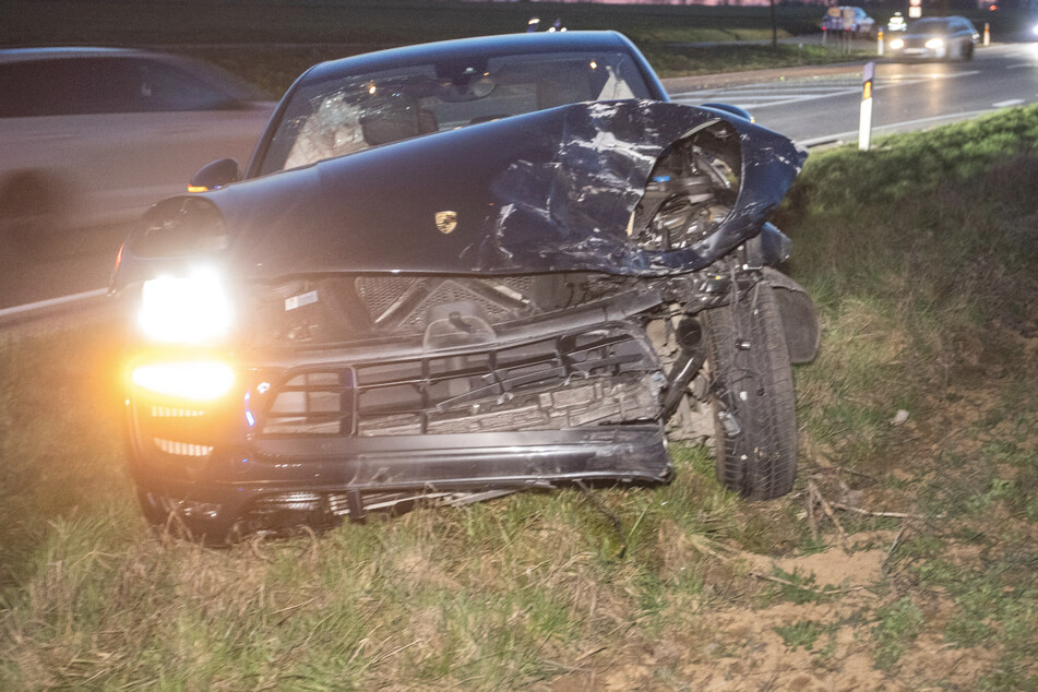 Der Porsche steht nach einem Unfall mit einem Peugeot in einem Grünstreifen. Der Peugeot-Fahrer und sein Beifahrer wurden schwer verletzt.