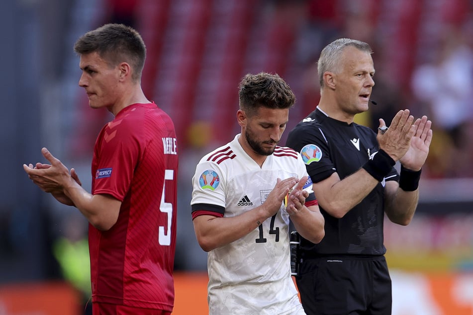 In der 10. Minute wurde die Partie zu Ehren Christian Eriksens unterbrochen. Dänemarks Joakim Maehle (l.), Belgiens Dries Mertens (M.) und Schiedsrichter Björn Kuipers applaudierten zusammen mit den Fans.
