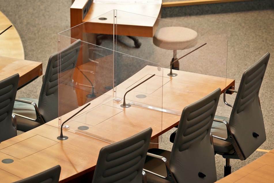 Der Prototyp einer Acrylglas-Kabine steht im Plenarsaal des nordrhein-westfälischen Landtages auf dem Tisch der Abgeordneten.