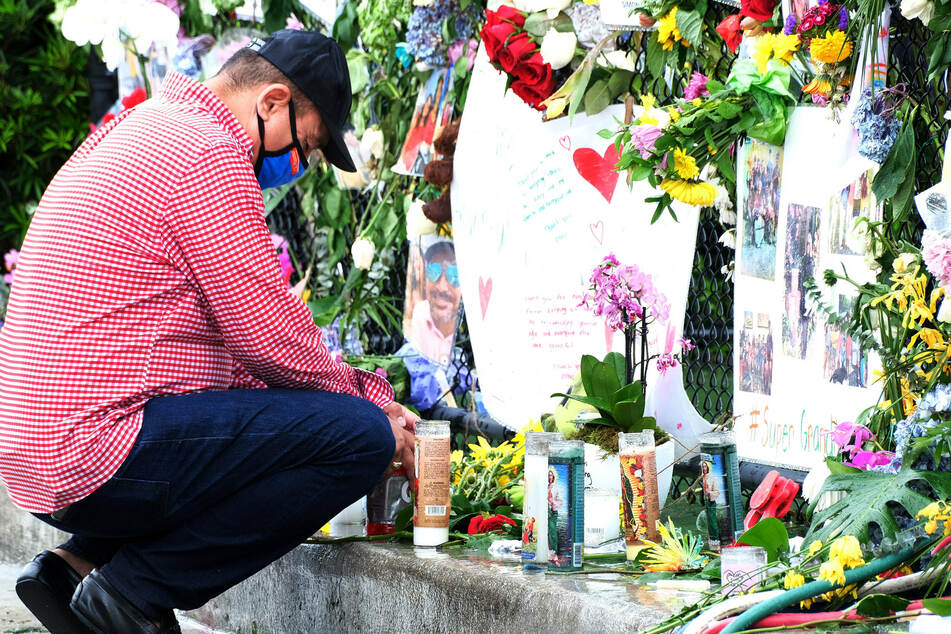 A man pays his respects at a makeshift memorial for victims at the site of the collapse.