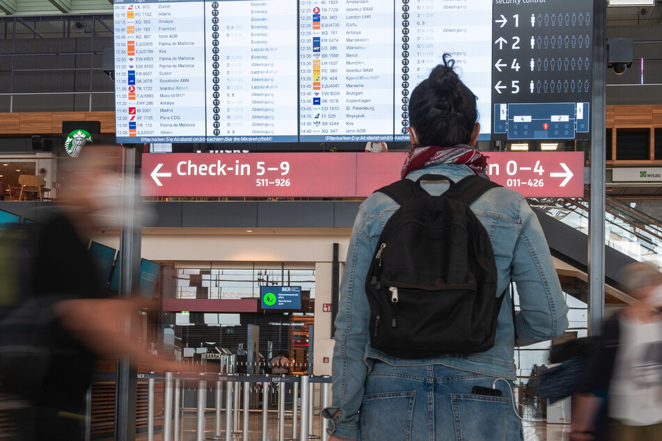 Berlin: Eine Frau steht vor einer Anzeigetafel im Terminal des Flughafens Berlin-Brandenburg (BER). Die Ausbreitung der Delta-Variante in Europa trübt die Urlaubsaussichten.