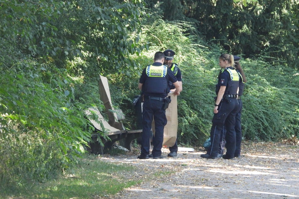 Die Polizeibeamten sichern die verdächtigen Gegenstände.