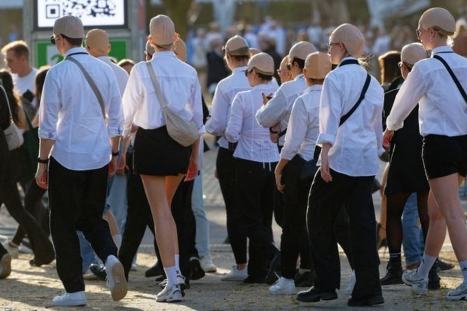 Weiße Hemden, schwarze Krawatten und Glatzenkappen: Tausende Fans kamen im typischen Pitbull-Look zum Konzert nach Düsseldorf.