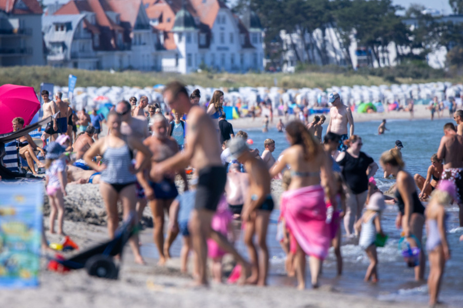 Badegäste tummeln sich am Strand in Warnemünde.
