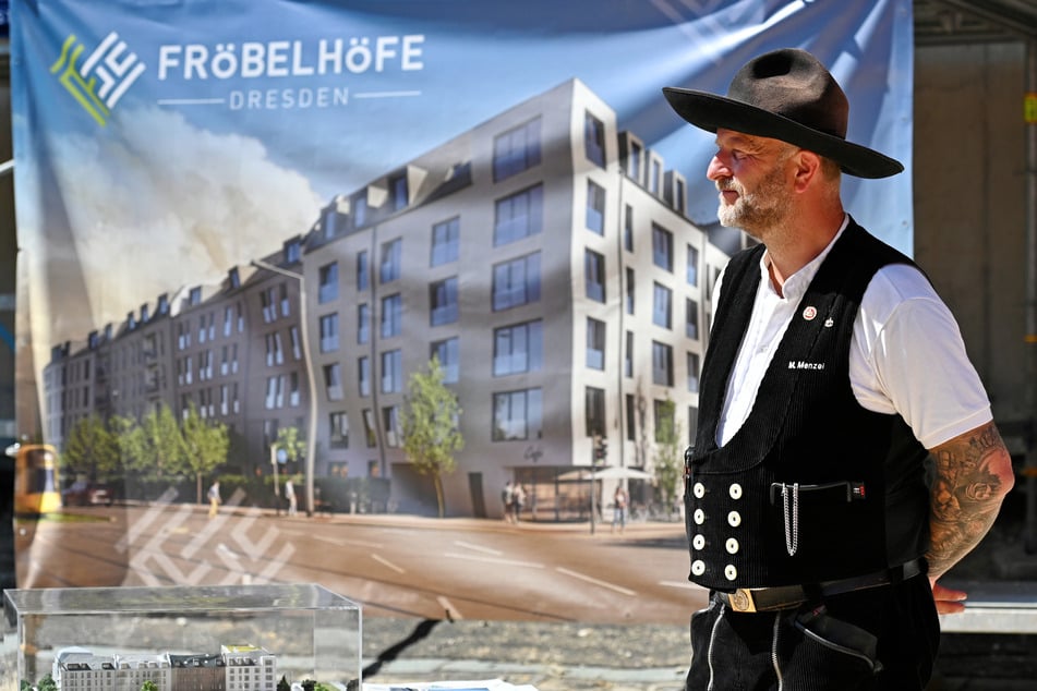 Ein Zimmerermann vor dem Werbebanner.