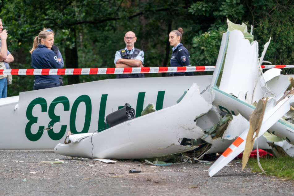 Das zerstörte Segelflugzeug auf dem Weg liegend.
