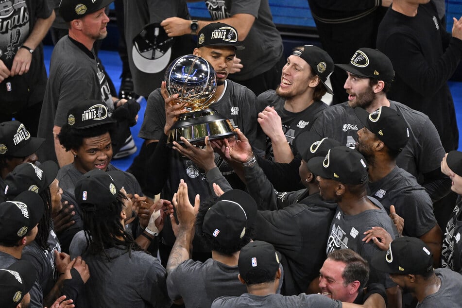 The San Antonio Spurs celebrate with the Oscar Robertson trophy after defeating the Oklahoma City Thunder in game seven of the Western Conference Finals for the 2026 NBA playoffs at Paycom Center on May 30, 2026.