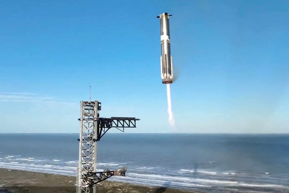 In this screen grab taken from the SpaceX broadcast the Starship's Super Heavy Booster returns to the launch pad at Starbase near Boca Chica, Texas, on Thursday.