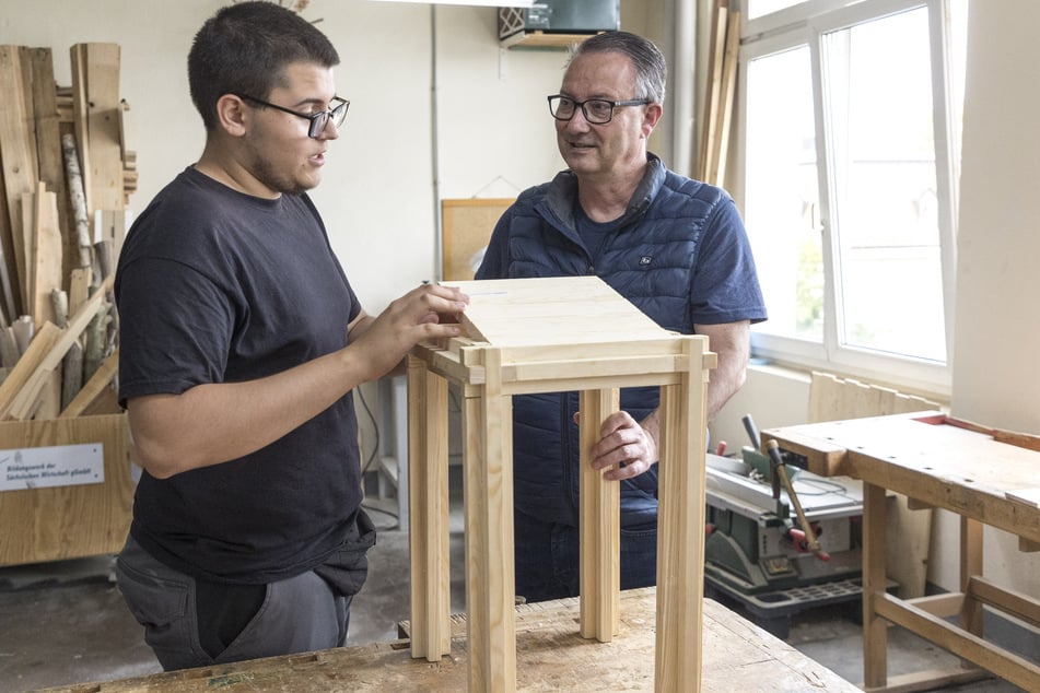 David Pinto (17) zeigt Bildungsbürgermeister Jan Donhauser (56, CDU) einen selbstgebauten Stuhl.