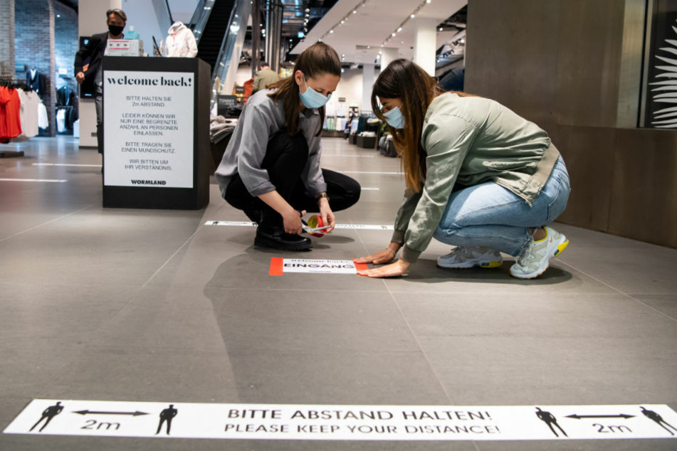 Mitarbeiterinnen eines Bekleidungsgeschäftes in der Mall of Berlin treffen Corona-Vorbereitungen. Am Freitag ist eine Gruppe von Maskengegnern durch das beliebte Einkaufszentrum gezogen.