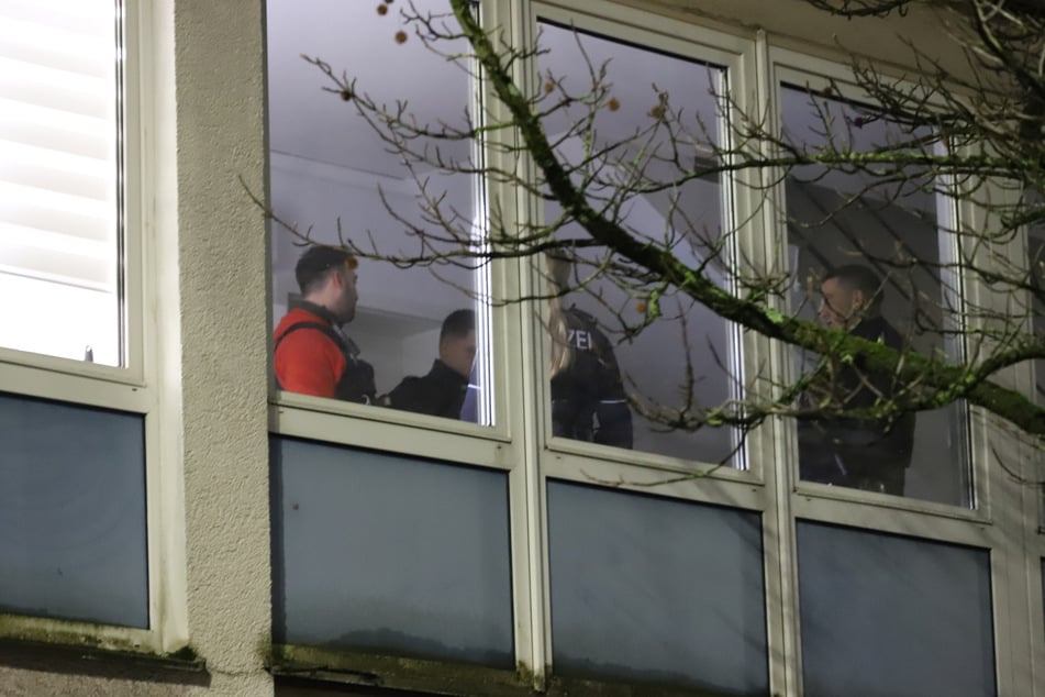 Polizisten stehen in der Nacht in der Wohnung, in der der Verletzte gefunden wurde.