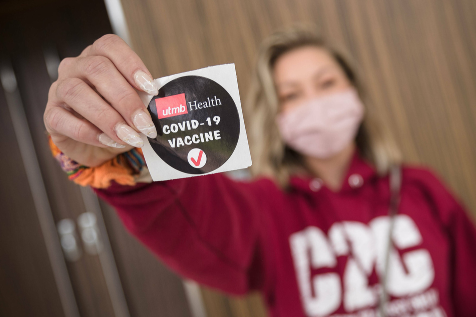 A patient displays a sticker proclaiming her recent Covid-19 inoculation during a mass vaccination event held by the University of Texas Medical Branch.