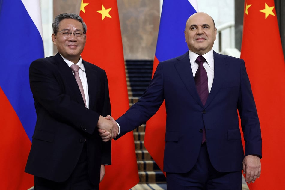 In this pool photograph distributed by the Russian state agency Sputnik, Russia's Prime Minister Mikhail Mishustin (r.) shakes hands with Premier of the State Council of China Li Qiang (l.) as they meet during the 29th meeting of the heads of government of Russia and China in Moscow on August 21, 2024.