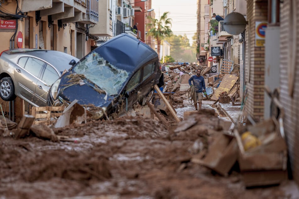 Schlamm, wohin das Auge reicht, in den Straßen von Valencia, in denen ein Mann mit den Aufräumarbeiten kaum hinterherkommt.